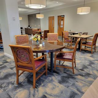A well-lit dining area with a table and chairs, featuring stylish interior design elements.