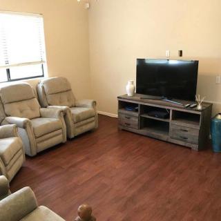 Cozy living room with reclining chairs and a television setup.