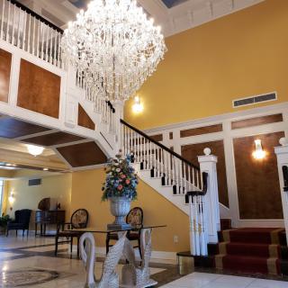 A grand lobby featuring a large chandelier and elegant staircase.