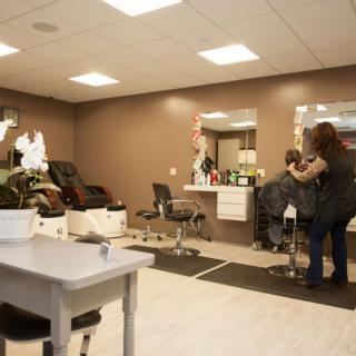 A cozy salon interior with a hairstylist cutting a customer's hair.