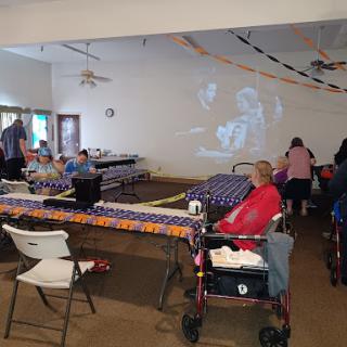 Seniors enjoying a community gathering with activities and a projector display.