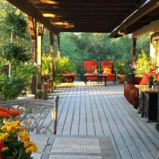 A cozy outdoor patio with seating and lush greenery.