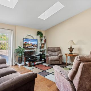 A cozy living room with comfortable seating, a television, and decorative indoor plants.