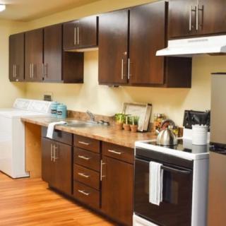 A modern kitchen with dark wooden cabinets and standard appliances.