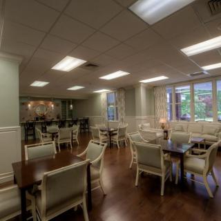 A well-lit dining room with chairs and tables arranged neatly.