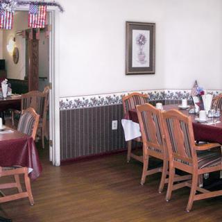 A cozy dining area in a restaurant with wooden tables and chairs, decorated with American flags.