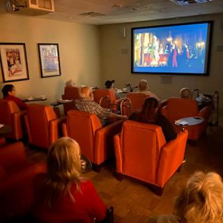 A small group of people watching a movie in a cozy screening room.