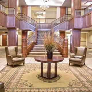 Elegant hotel lobby with a grand staircase and comfortable seating.