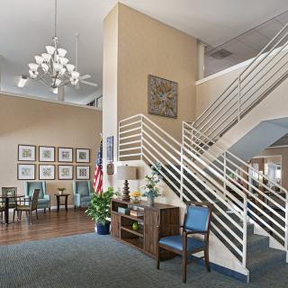 A modern lobby with seating area, decorative lighting, and a staircase.