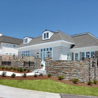 A modern residential house with stone walls and well-maintained landscaping.