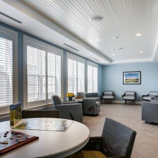 A modern waiting room with comfortable seating and large windows letting in natural light.
