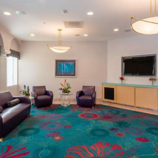 A modern lobby with comfortable seating and a colorful carpet.