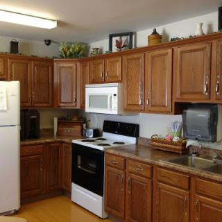 A cozy kitchen featuring wooden cabinets and essential appliances.