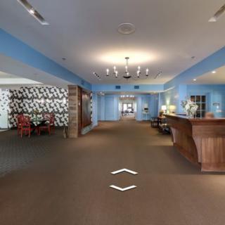 Modern hotel lobby with a reception desk and seating area.