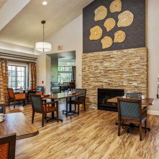 A modern dining area with wooden flooring, stylish furniture, and a decorative fireplace.