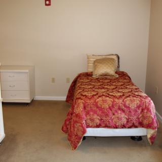 A minimalist bedroom with a single bed and nightstand.