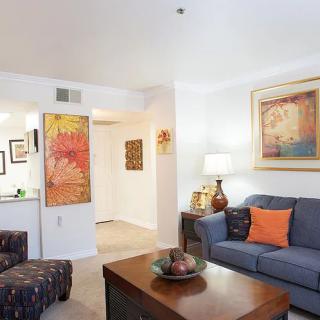 A cozy living room with a comfortable sofa, colorful cushions, and decorative artwork on the walls.