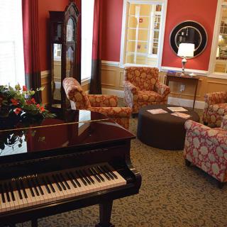 A cozy lounge with a grand piano and comfortable seating arrangements.