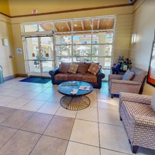 A cozy lobby area with a sofa, armchairs, and a coffee table near the entrance.