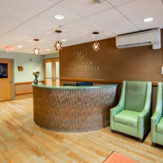 A modern reception area with green chairs and a wooden front desk, designed for a welcoming healthcare experience.