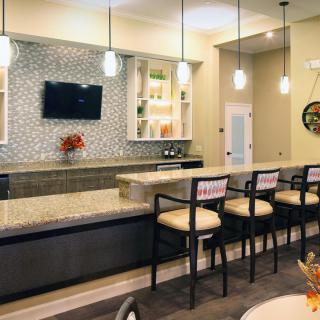 A modern bar interior with a sleek counter, comfortable seating, and ambient lighting.