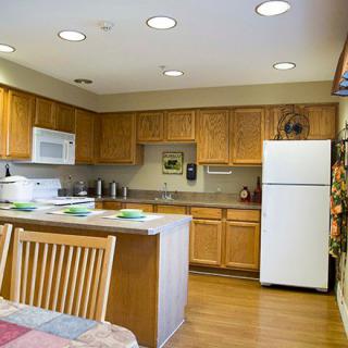 A modern kitchen with wooden cabinets and a dining area.