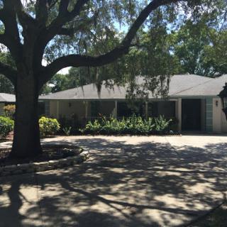 A charming residential home with a well-maintained front yard and a large tree providing shade.