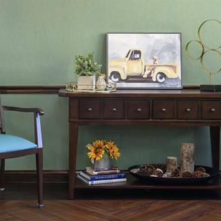 A cozy interior with a decorative table and a painting of a vintage truck.