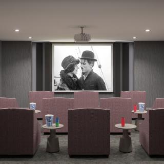 A cozy home theater setup showcasing a classic black and white movie on the projector screen.