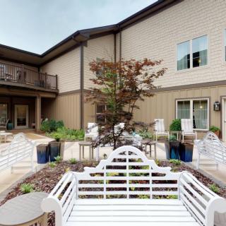 A peaceful courtyard featuring benches and lush landscaping in a residential building.
