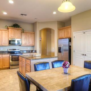 A modern kitchen and dining area with wooden cabinets, stainless steel appliances, and a cozy dining table.