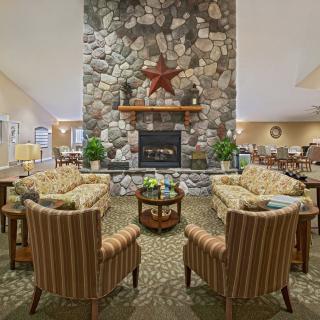 A cozy living room with a stone fireplace and comfortable seating.