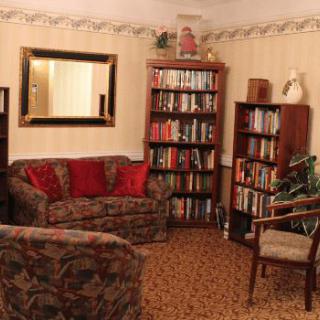 A cozy living room with bookshelves, a sofa, and an armchair.