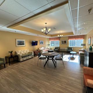 A spacious lounge area featuring comfortable seating, natural light, and inviting decor.