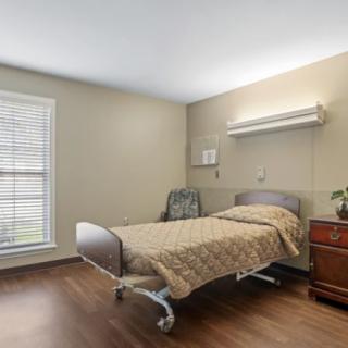 A minimalist hospital room with a single bed and medical equipment.
