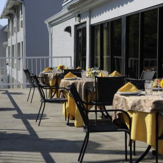 An outdoor restaurant patio with tables and chairs set for dining during the daytime.