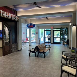A modern waiting area with comfortable seating and a theater entrance.