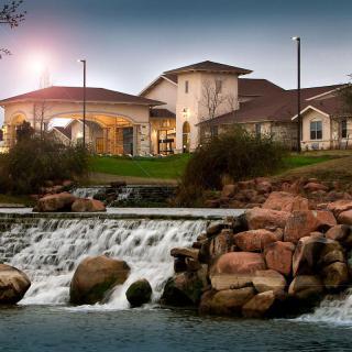 A beautiful evening view of a building with a waterfall in the foreground.