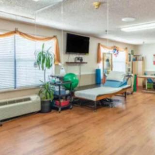 A well-equipped rehabilitation room with exercise equipment and therapy bed.
