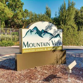 Entrance sign for Mountain View with scenic nature backdrop.