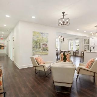A modern living space with an open layout, featuring stylish furniture and wood flooring.
