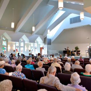 A serene gathering of seniors attending a service at a church.