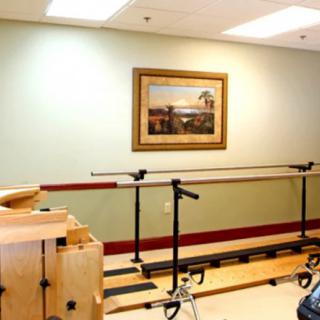 A physical therapy room featuring parallel bars used for rehabilitation exercises.