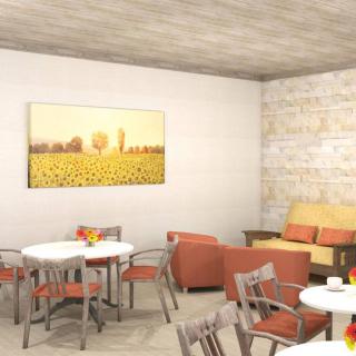 A modern and cozy dining area with circular tables, cushioned chairs, and decorative artwork on the wall.