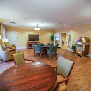A cozy living room with seating, tables, and a television.