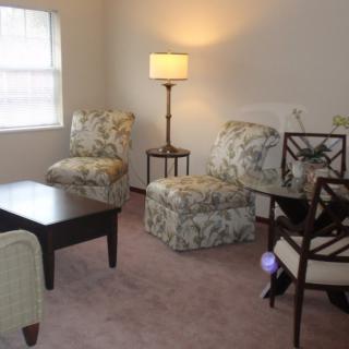 A cozy living room with patterned chairs and a coffee table.
