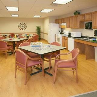A cozy dining and kitchen area with a table, chairs, and appliances.