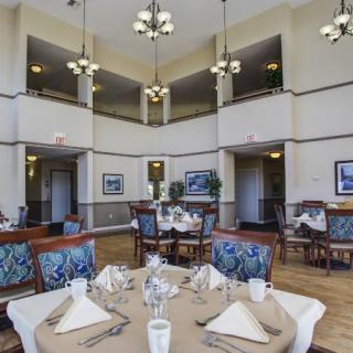An elegant dining room featuring well-set tables and chandeliers.