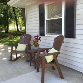 A cozy outdoor seating area featuring two rocking chairs and a small table, perfect for enjoying a peaceful moment.
