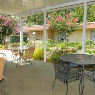 A tranquil patio with tables and chairs overlooking a garden.